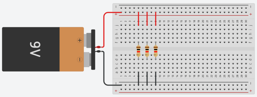 Circuito com três resistores conectados em paralelo em uma protoboard, alimentado por uma bateria de 9V.